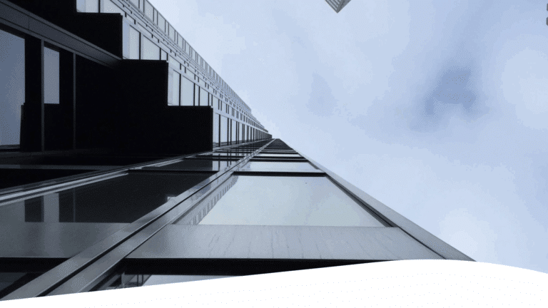 A low angle view of skyscrapers against a cloudy sky.